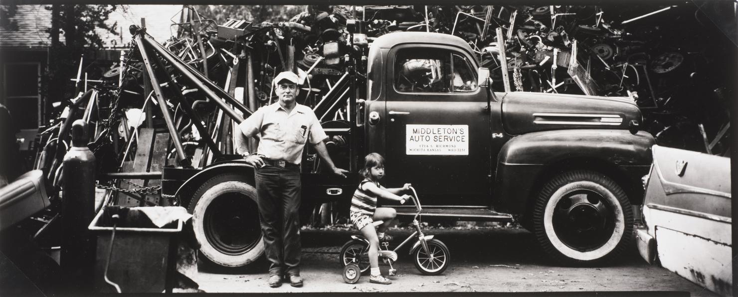 untitled (man and child in front of a tow truck) by Thaddeus Holownia