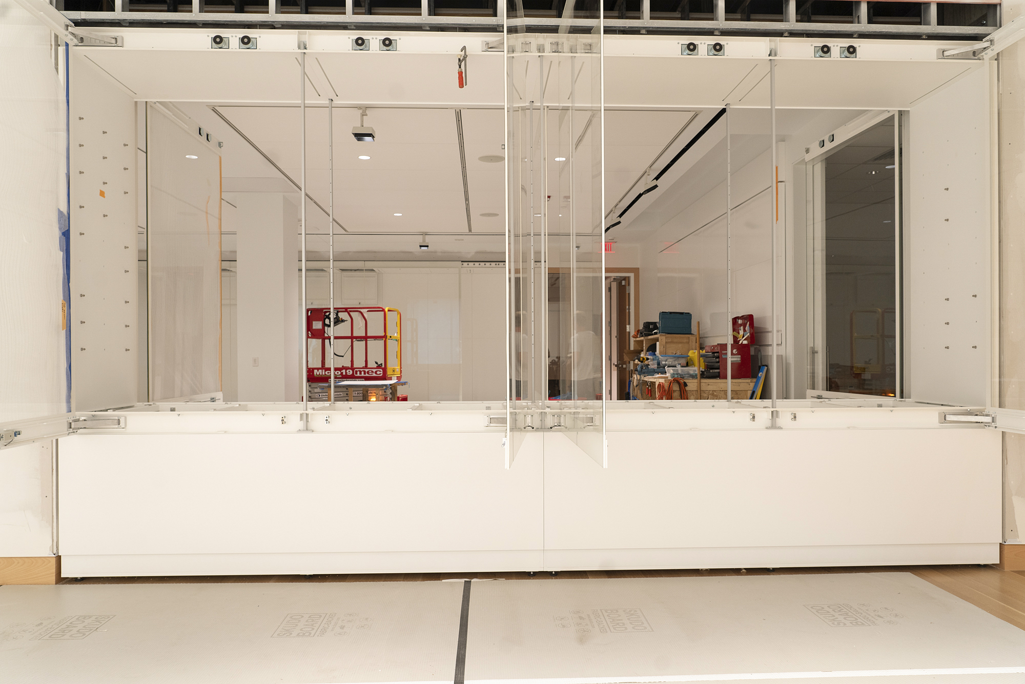 A wall of open glass cases in a bright white room