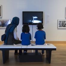 Visitors watch a video in the exhibition "Temporal Turn: Art and Speculation in Contemporary Asia".