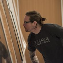 A student inspects a work of art in the Stephen H. Goddard Study Center.