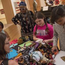 Artist Faith Ringgold works with students during a quilt workshop.