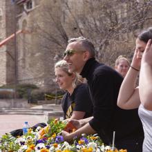 Artist Paul Hartfleet and Spencer Museum interns give pansies away to passersby in from of the Kansas Memorial Union