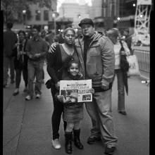 <a href='https://spencerartapps.ku.edu/collection-search#/object/62944' target='_blank'><i>A family displaying the first edition of the Occupied Wall Street Journal</i> by Accra Shepp</a>